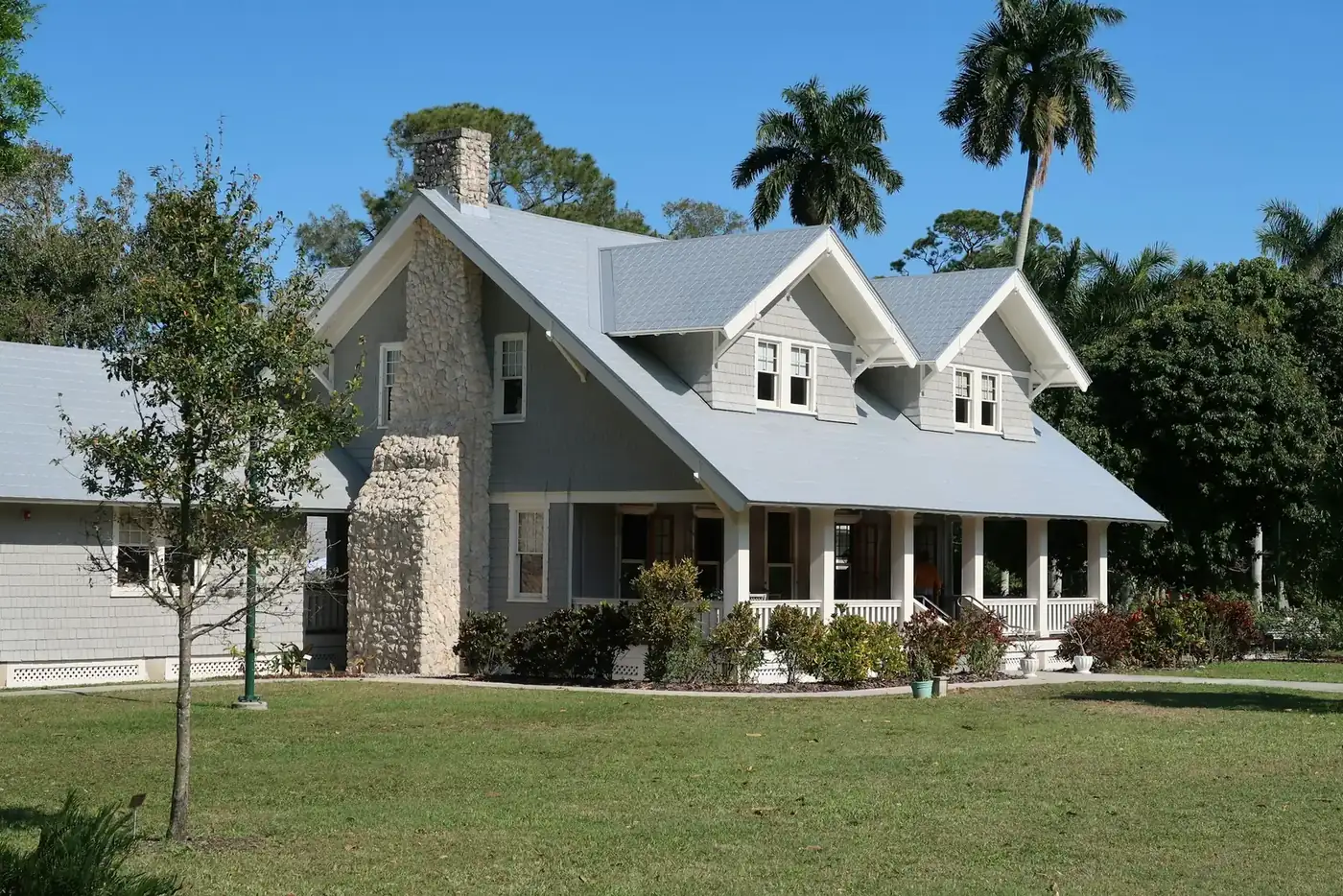 A Florida home with palm trees and a green front lawn